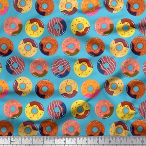 May include: A repeating pattern of colourful doughnuts on a light blue background. The doughnuts have various toppings and colours, including pink, yellow, brown, and white. The image is a close-up, showing the details of the doughnuts.
