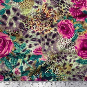 Peut inclure: Tissu avec un motif floral et animalier vibrant. Le motif présente de grandes roses roses, des feuilles vertes et un fond à imprimé léopard. Le tissu est mesuré avec une règle en centimètres.
