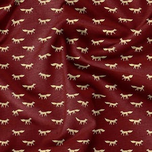 May include: Burgundy fabric featuring a repeating pattern of small, gold-coloured fox silhouettes. The fabric has a slightly textured appearance with soft folds and shadows, creating a sense of depth and movement. The foxes are evenly spaced across the surface.