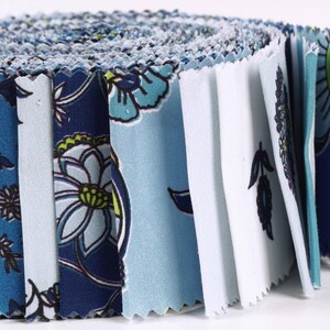 May include: A roll of blue and white fabric with a floral pattern. The fabric is cut into squares and is ready to be used for quilting or other crafts.