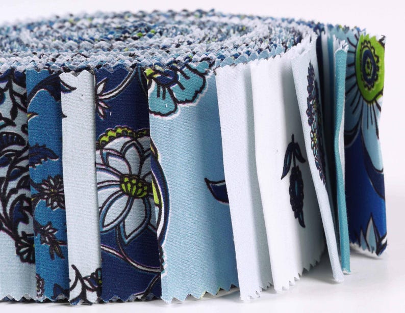 May include: A roll of blue and white fabric with a floral pattern. The fabric is cut into squares and is ready to be used for quilting or other crafts.