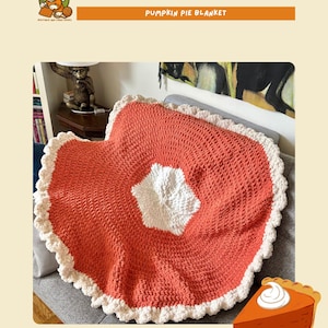 Puede incluir: Una manta de ganchillo con forma de tarta de calabaza, de 107 cm de diámetro. La manta presenta un centro naranja vibrante, un relleno blanco en forma de estrella y un borde festoneado color crema. El texto "CROCHET PATTERN PUMPKIN PIE BLANKET" se muestra en la parte superior.