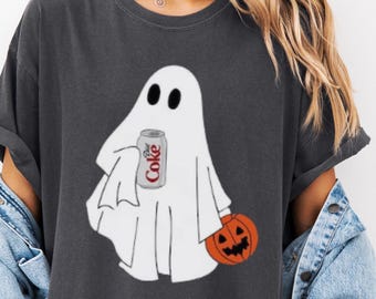 Op de afbeelding: Donkergrijs t-shirt met een cartoon spook met een Coca-Cola blikje en een uitgesneden pompoen. Het spook draagt een wit laken en heeft zwarte ogen. De pompoen is oranje met een uitgesneden gezicht. Het Coca-Cola blikje is rood en wit.