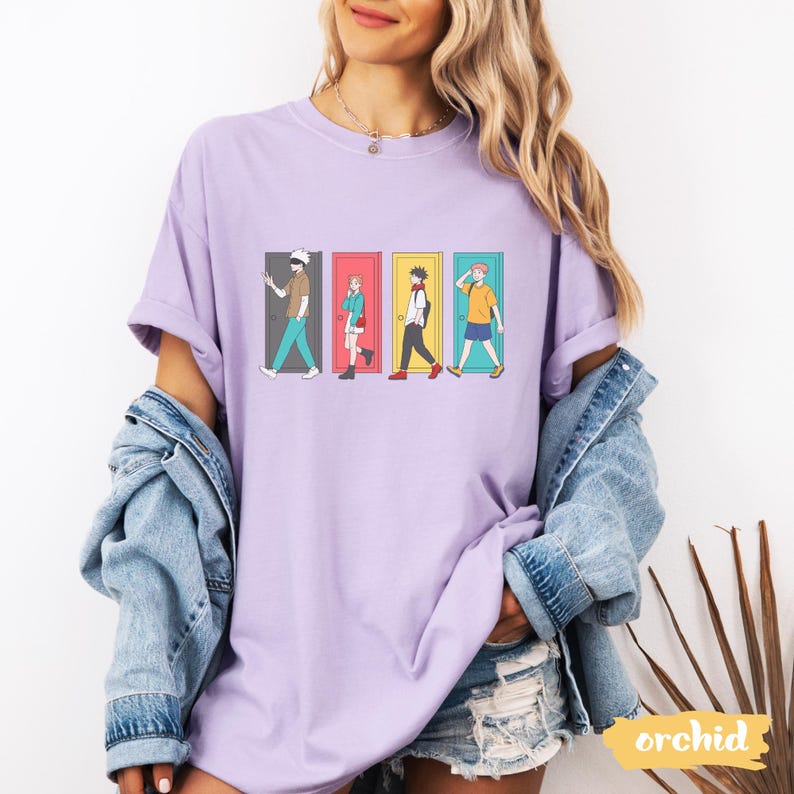 May include: A lilac-colored t-shirt featuring a graphic of four figures walking through different colored doorways. The figures are in various outfits. The word "orchid" is printed on a yellow label in the bottom right corner.