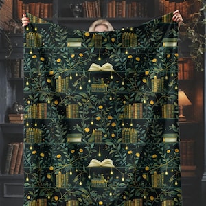 May include: A dark green blanket with a repeating pattern of books, vines, and yellow flowers. The blanket has a cozy, inviting aesthetic, perfect for a reading nook or library-themed decor. The design includes open books and string lights.