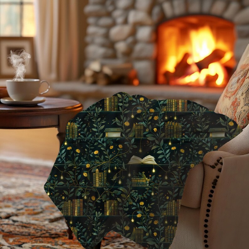May include: A dark green throw blanket featuring a pattern of bookshelves, leaves, and yellow flowers. The blanket is draped over a chair in front of a fireplace, creating a cosy, warm atmosphere.