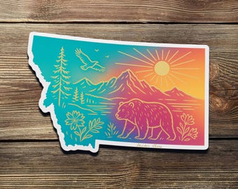 Pegatina de atardecer en Montana: Oso grizzly, montañas y flores silvestres - Vinilo impermeable