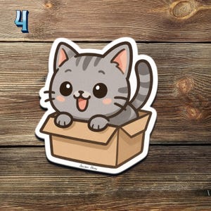 May include: A sticker featuring a cartoon gray tabby cat peeking out of a cardboard box. The cat has large eyes, pink inner ears, and a happy expression. The number "4" is in the upper left corner.