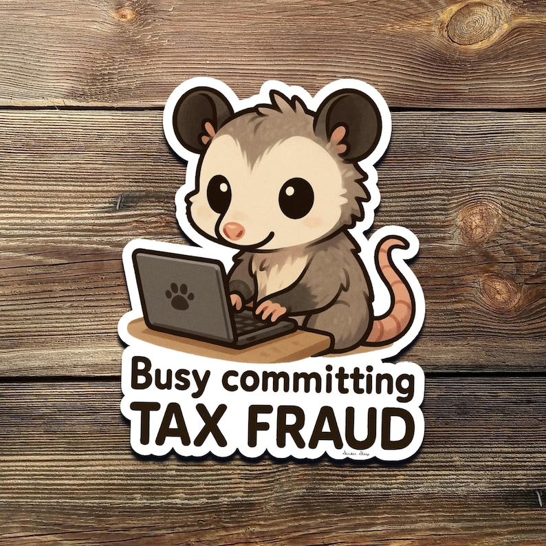 K&ouml;nnte beinhalten: Ein Aufkleber mit einem Cartoon-Opossum mit einem Laptop. Das Opossum ist grau und hellbraun mit gro&szlig;en schwarzen Augen und sitzt an einem kleinen Schreibtisch. Der Text "Busy committing TAX FRAUD" steht darunter.