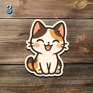 May include: A smiling cartoon cat sticker with a white body, brown and orange patches, and pink cheeks. The sticker is on a wooden surface. A blue number 3 is in the upper left corner.