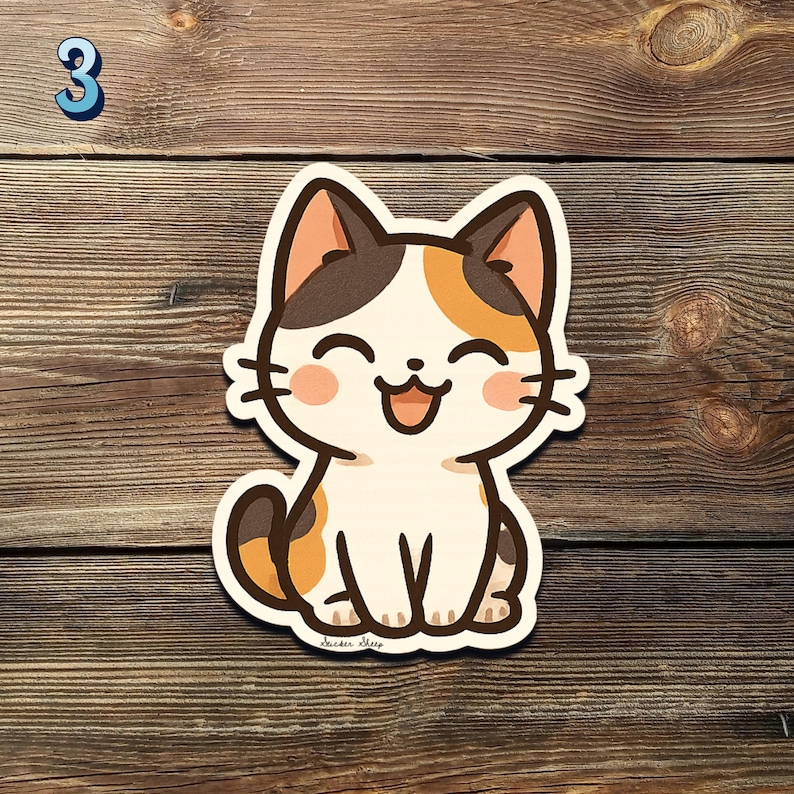 May include: A smiling cartoon cat sticker with a white body, brown and orange patches, and pink cheeks. The sticker is on a wooden surface. A blue number 3 is in the upper left corner.