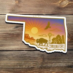 May include: A sticker in the shape of Oklahoma, featuring a sunset, a bison, an eagle, a windmill, and a cabin. The sticker has a gold outline and the text "Sucker Sleep". The background is a wooden surface.