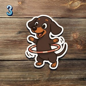 May include: A sticker of a cartoon dachshund dog with brown fur, a tan snout, and floppy ears, spinning a pink and white hula hoop. The number 3 is in the upper left corner. The sticker is on a wooden background.