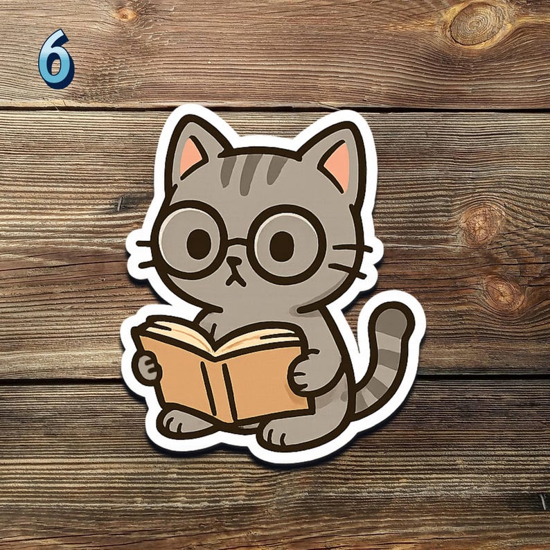 May include: A sticker featuring a cartoon cat wearing glasses and reading a book. The cat is gray with black stripes and is holding an open book with a tan cover. The sticker has a white border and is set against a wooden background.