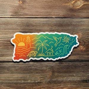 May include: A colorful sticker in the shape of Puerto Rico, featuring a sunset, lighthouse, palm tree, bird, and waterfall. The design includes the text "Sticker Shore" and a turtle. The sticker is on a wooden surface.