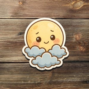 Puede incluir: Una pegatina troquelada con una luna de dibujos animados con una cara sonriente y mejillas rosadas, asomando por detrás de nubes azules esponjosas. La pegatina está sobre una superficie de madera.