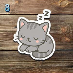 May include: A gray cartoon cat sticker with closed eyes and pink inner ears, sleeping with 'Zz' above its head. The sticker has a white border and the text 'Sticker Sheep' at the bottom. A blue number 8 is in the top left corner.