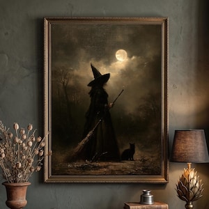 May include: A framed wall art print depicting a silhouette of a figure in a pointed hat holding a broomstick, standing with a black cat under a full moon in a dark, cloudy landscape. The artwork is encased in a simple, thin gold-toned frame.