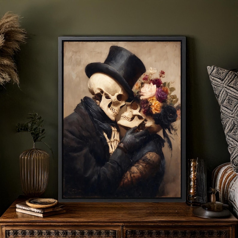 May include: A framed artwork depicts two skeletons embracing. One skeleton wears a black top hat and coat, the other is adorned with a floral crown. The painting has a vintage aesthetic with a dark color palette, creating a romantic and gothic theme.