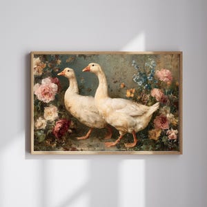 May include: A framed art print featuring two white geese with orange beaks and feet, set against a backdrop of colorful flowers. The artwork has a vintage aesthetic, with soft lighting and a muted color palette.