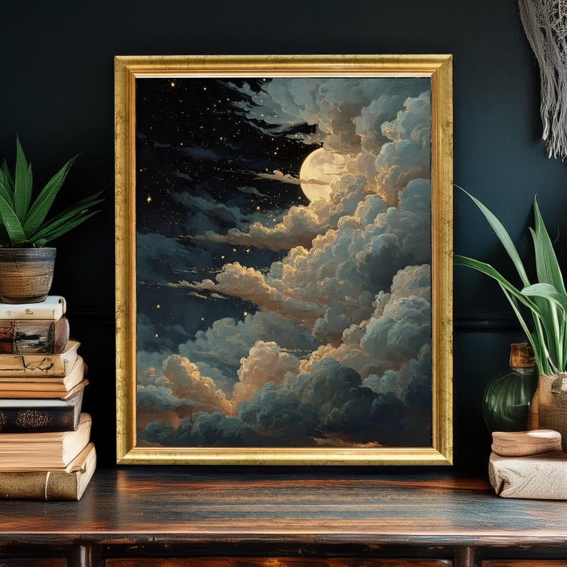Op de afbeelding: Een ingelijste kunstdruk die een nachtlandschap met een volle maan, wolken en sterren afbeeldt. Het kunstwerk heeft een gouden lijst en een kleurenpalet van blauw, goud en wit. De print wordt weergegeven op een donker houten oppervlak.