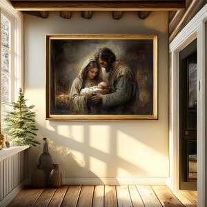May include: A framed painting depicting a religious scene with a man, woman, and baby. The artwork is in a gold frame and hangs on a cream-colored wall. The room has a wooden floor and a small Christmas tree in the corner.