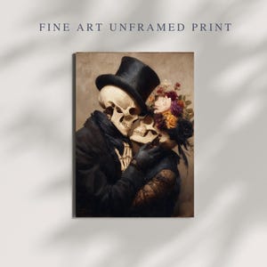 May include: Fine art print featuring a romantic embrace between two skeletons. One skeleton wears a black top hat and coat, while the other is adorned with flowers. The artwork has a vintage aesthetic and the text "FINE ART UNFRAMED PRINT" is at the top.