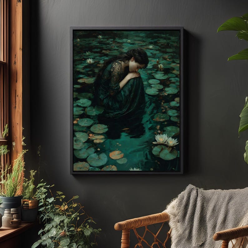 May include: A framed art print depicts a woman in a dark green dress, seated in a pond filled with lily pads and white water lilies. The artwork has a dark, moody aesthetic, with a focus on the woman's contemplative pose.