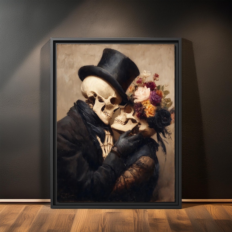 May include: Framed artwork depicting two skeletons embracing. One skeleton wears a black top hat and coat, the other is adorned with flowers. The artwork has a vintage, romantic theme with a dark color palette.