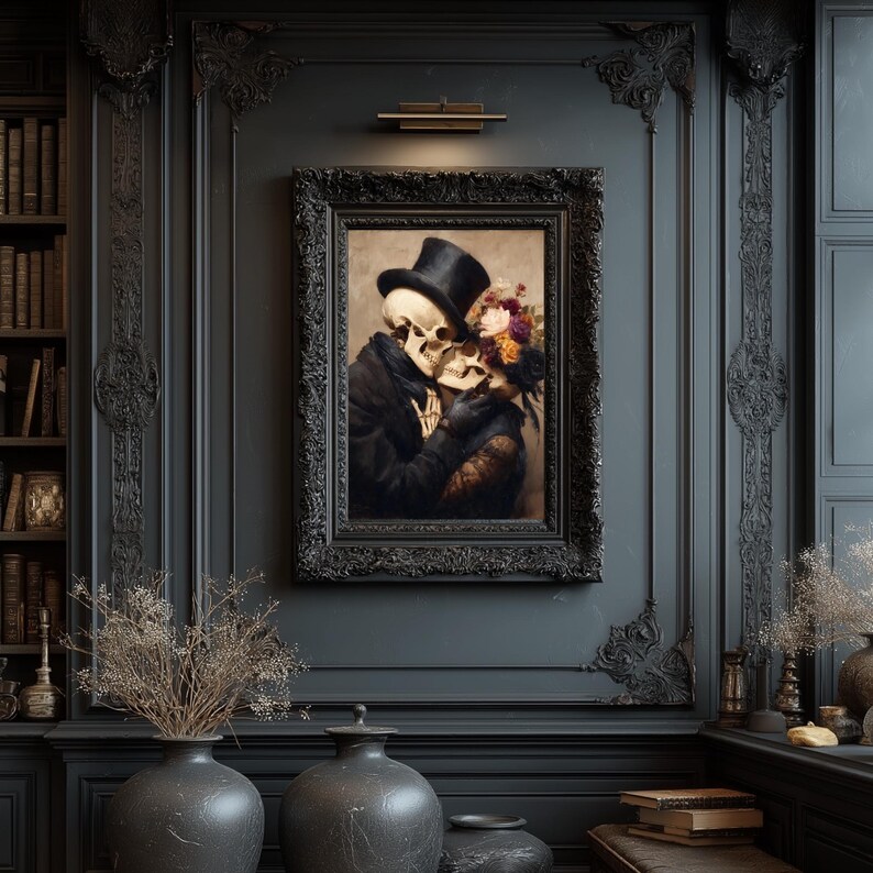 May include: A framed artwork depicts two skeletons embracing, one wearing a top hat and the other adorned with flowers. The painting is set against a dark, ornate wall, with decorative vases and a bookshelf visible in the background. The frame is black.