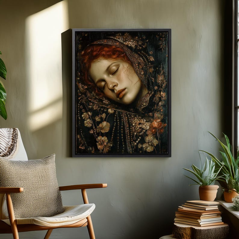 May include: A framed art print depicts a woman with red hair and closed eyes, adorned with floral details. The artwork features a dark background with gold and brown accents, creating a vintage aesthetic. The print is displayed in a room with a chair and plants.