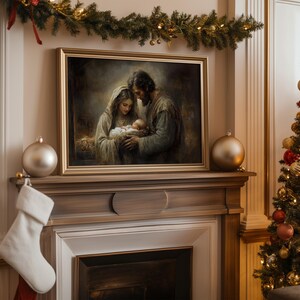 May include: A framed painting depicting a religious scene of a family with a baby, displayed above a fireplace. The painting has a gold frame and is surrounded by Christmas decorations, including ornaments, a stocking, and a garland.