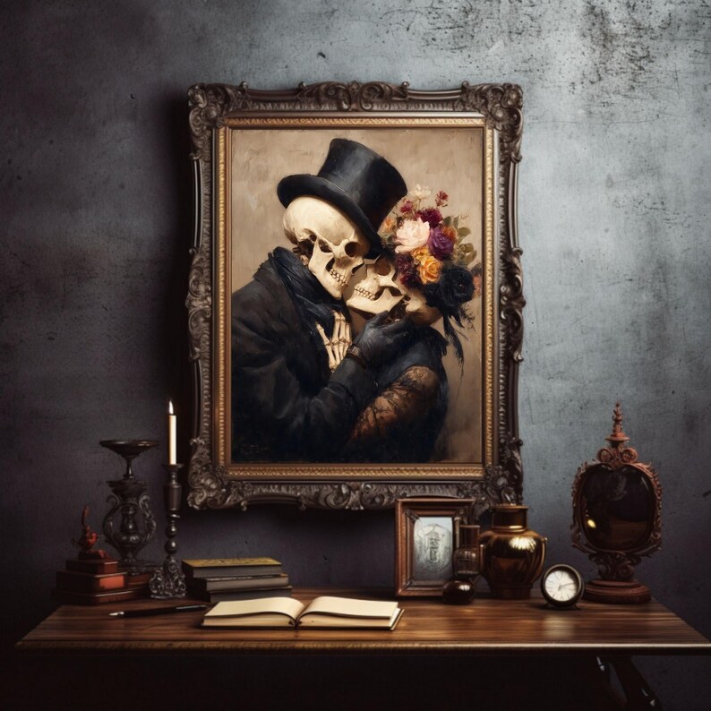 May include: A framed painting depicts two skeletons embracing, one wearing a top hat and the other adorned with flowers. The artwork is set against a dark, textured wall, with a wooden table in the foreground holding various decorative items.