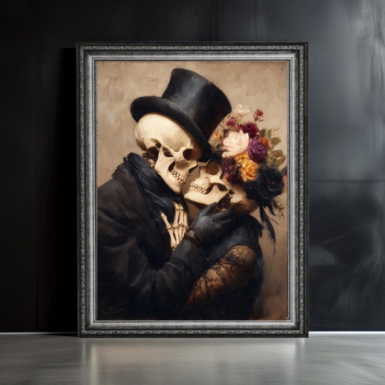 May include: A framed artwork depicts two skeletons embracing. One skeleton wears a black top hat and coat, the other a floral headpiece and black gloves. The artwork has a dark, romantic theme with a vintage aesthetic.