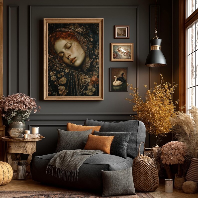 May include: A cozy living room scene with a large framed portrait of a woman with red hair, and several smaller framed paintings. A gray sectional sofa is adorned with orange and gray pillows and a gray throw blanket. Decorative dried flowers and a woven basket add warmth.