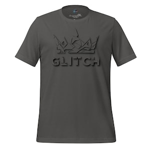 以下が含まれることがあります： ダークグレーのTシャツ。スタイリッシュな王冠のデザインと「GLITCH」の文字が3D効果で描かれています。デザインは濃いグレーで、シャツのベースカラーと微妙なコントラストを生み出しています。クルーネックと半袖のデザインです。