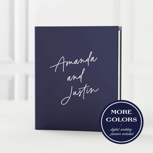May include: A navy blue wedding planner with the names "Amanda and Justin" in white script. A circular badge in the lower right corner reads "MORE COLORS" and "digital wedding planner included".