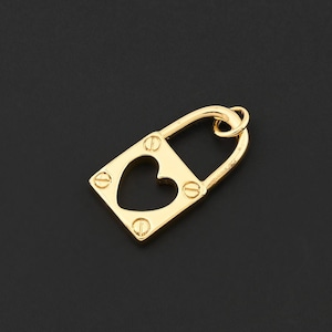 May include: A gold-colored padlock charm with a heart-shaped cutout in the center. The charm has a rectangular body with rounded corners and is secured by a curved handle. Small screws are visible on the front.