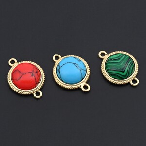 May include: Three gemstone connector charms. The charms feature a round stone in red, turquoise, and green, each set in a gold-colored bezel with a beaded edge. Each charm has two loops for attaching to jewelry.