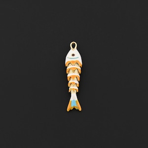 May include: A gold-colored fish pendant with white, orange, and blue enamel detailing. The fish-shaped charm has a loop at the top for hanging and is set against a black background. The pendant is likely for jewelry making.