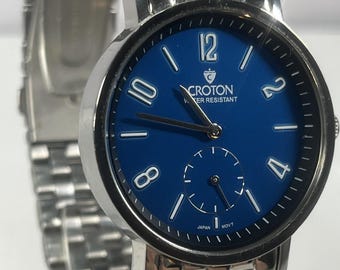 Croton watch featuring a vibrant blue dial, multi-link stainless steel bracelet, functional second's sub-dial at the 6 o'clock position.
