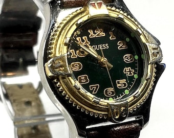 Vintage Guess watch features a green face silver and gold case and a worn brown leather band from the 1990s. New battery installed