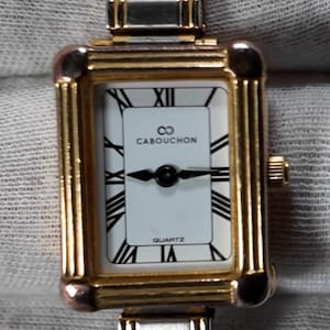 Montre vintage pour femme de la marque Cabouchon avec un boîtier rectangulaire doré et un bracelet extensible bicolore (argent-or). Nouvelle batterie installée