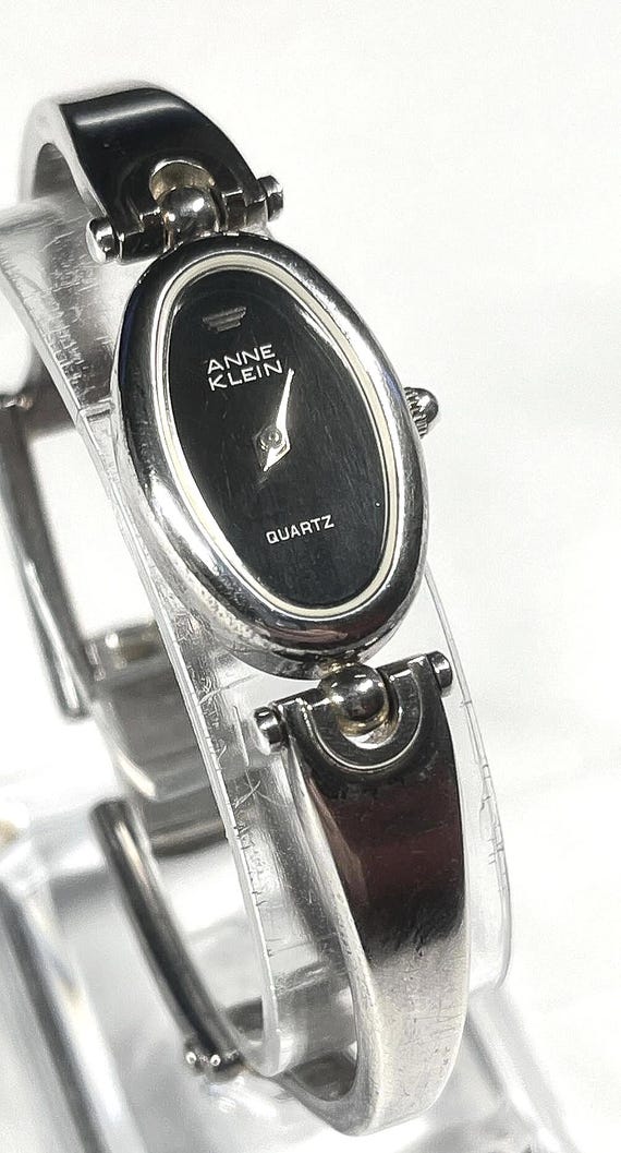 Anne Klein II women's quartz watch featuring an oval face, a black dial, and a silver-tone link bracelet. new battery