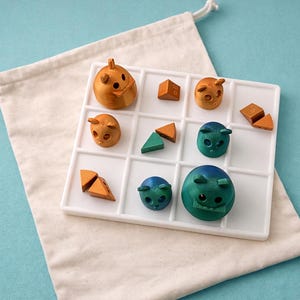 Op de afbeelding: Een houten puzzelspel met een wit raster, met bruine en blauwgroene dierfiguren en geometrische vormen. Het spel staat op een wit oppervlak, met een beige trekkoordtas op de achtergrond, alles tegen een lichtblauwe achtergrond.