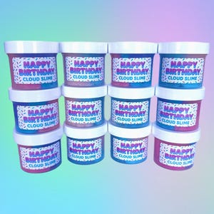 May include: A stack of cloud slime containers with white lids. Each container has a label that reads "Happy Birthday Cloud Slime" with colorful sprinkles. The slime colors are pink and blue.