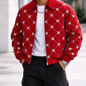 May include: A red quilted jacket with a white floral pattern and a silver zipper. The jacket has a collar and is worn over a white t-shirt and black cargo pants. A silver watch and chain are visible.