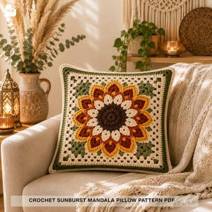 Pode incluir: Uma almofada quadrada de crochê com um design central de mandala em forma de sol com camadas de fio marrom escuro, creme, amarelo e cor de ferrugem. O motivo floral é emoldurado por uma borda creme e verde oliva. O texto CROCHET SUNBURST MANDALA PILLOW PATTERN PDF é visível.