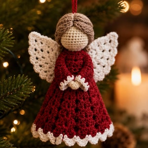May include: A crocheted angel ornament featuring a deep red dress with white scalloped trim at the hem and sleeves. The figure has a beige crocheted head, light brown yarn hair, and white crocheted wings. A red string is attached to the top for hanging.