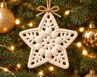 May include: A cream-colored, star-shaped crochet ornament featuring a textured, puff-stitch floral center and intricate openwork detailing. The ornament is suspended by a thin, natural-toned jute twine tied into a small bow at the top.